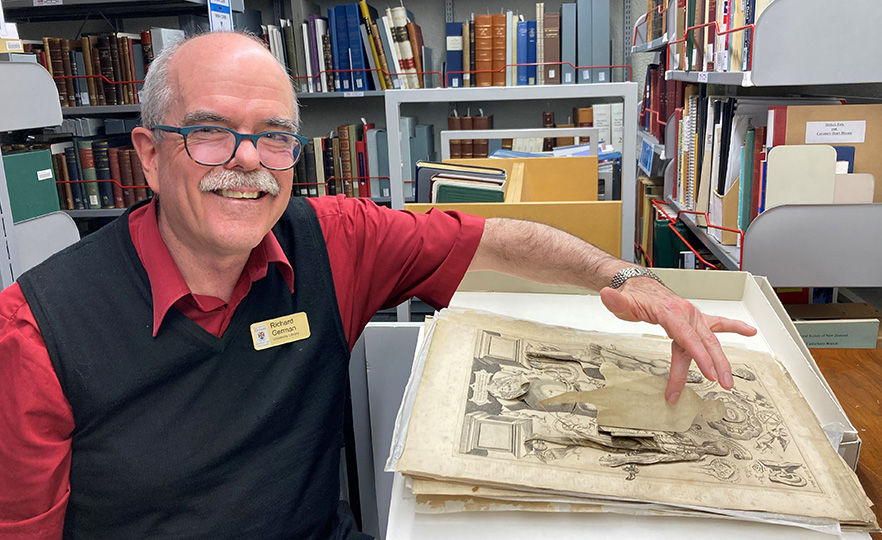 Richard German with a visibly aged centuries-old 'pop up' anatomy plate in Health Sciences library image