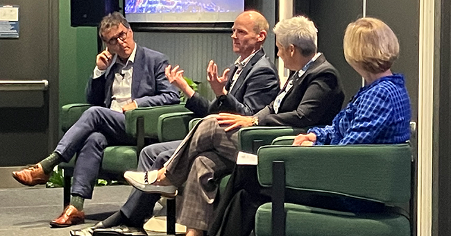 Four people seated on a stage 