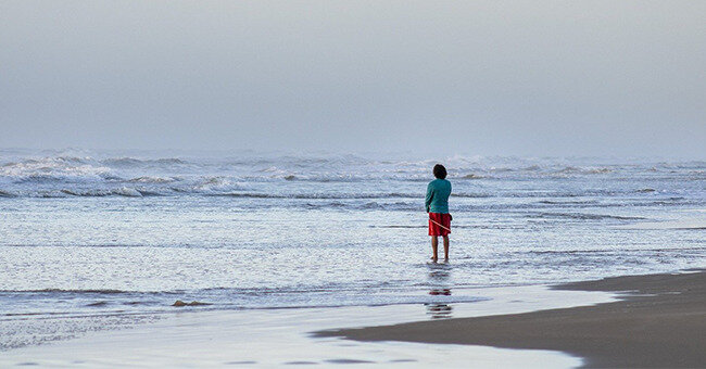 A person stands on a beach 