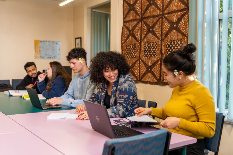 students at a tablewith a tapa cloth in the background