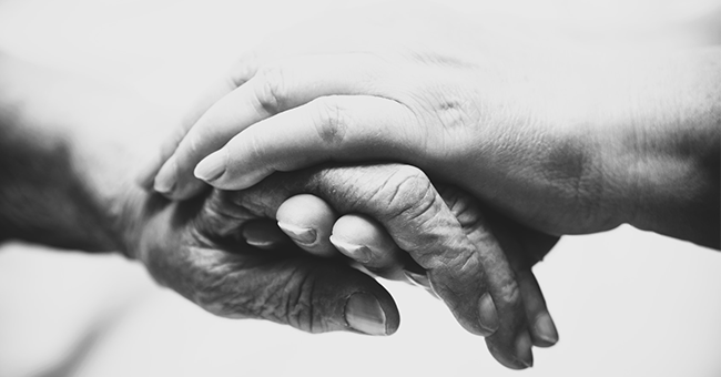 Image of person holding older person's hand