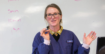 Lecturer standing in front of a whiteboard.