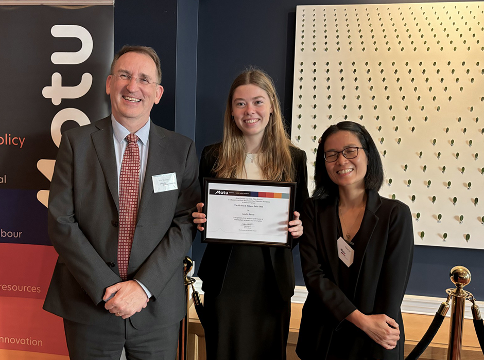 Amelia Farrar (centre) receiving her prize from Motu Executive Director John McDermott and Motu Senior Fellow Trinh Le.