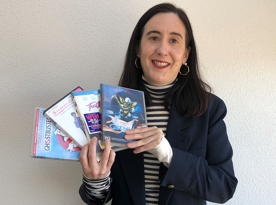 A woman holding four DVDs 