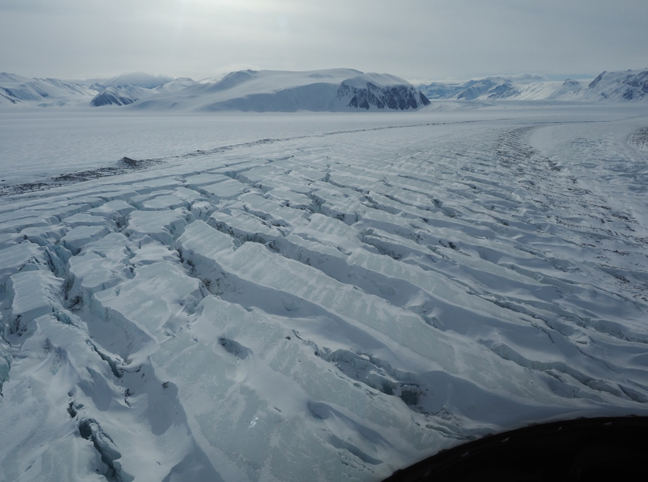 A glacier in Priestley Glacier, Terra Nova Bay, Antarctica, featuring debris which has fallen from higher in the mountains. The surface of the glacier is fractured by the middle of the glacier moving much faster than the edge of the glacier. 