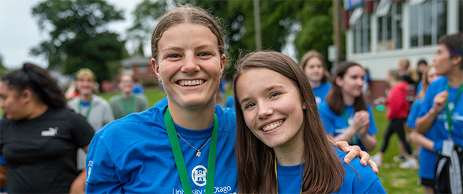 Two smiling young women wearing Hands-on Otago t-shirts and lanyards