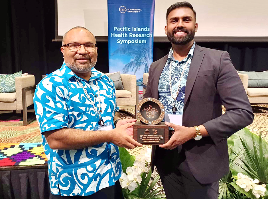 One man gifting an award to another, both are smiling