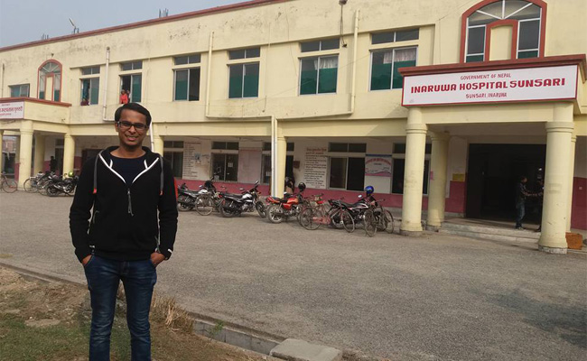 Roshit standing in front of Inaruwa Hospital, Sunsari, Nepal, where he was born.