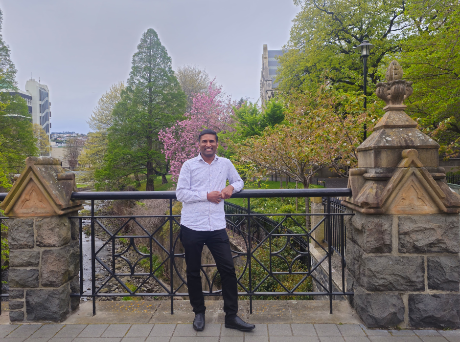 A man standing on a the Union St bridge on campus