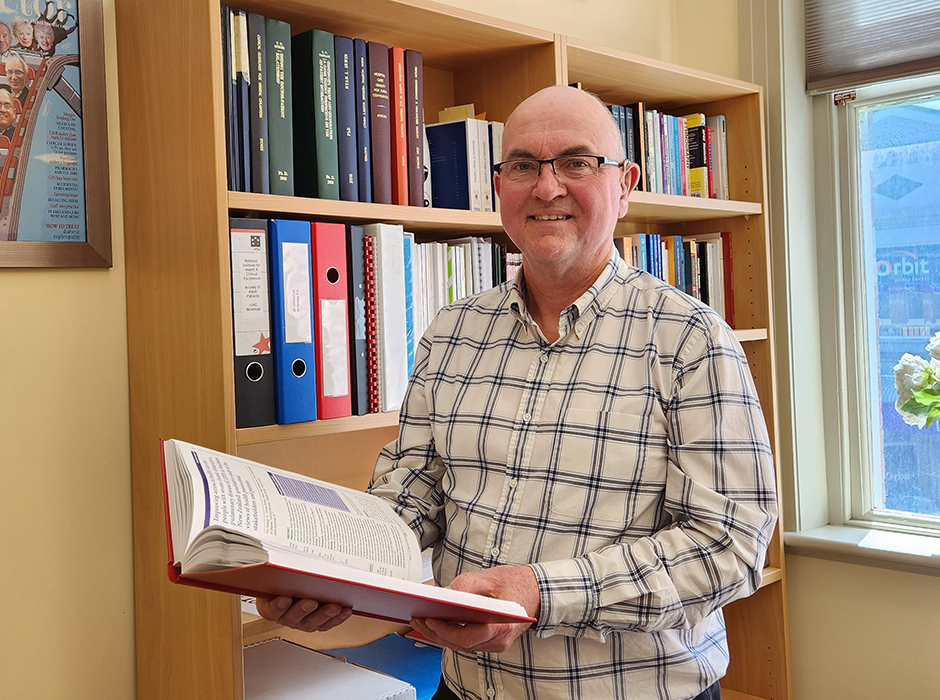 Professor Tim Stokes holds his MD thesis, which represents two decades of research across two countries. 