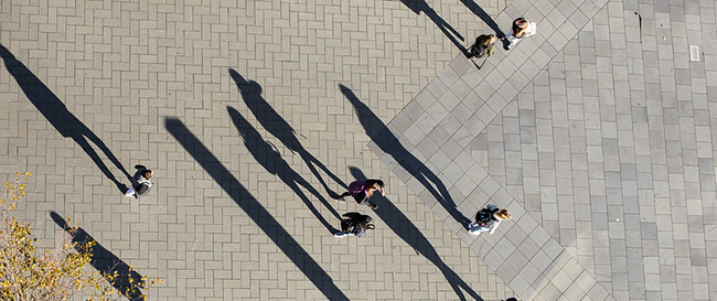 View from above of people walking on a decoratively paved outdoor area