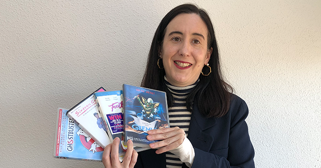 A woman holding four DVDs 