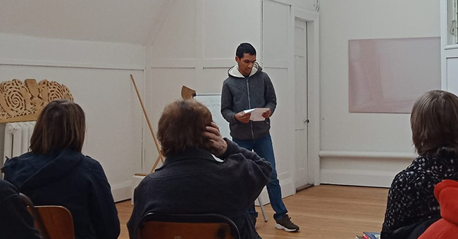 A man reading poetry to an audience 