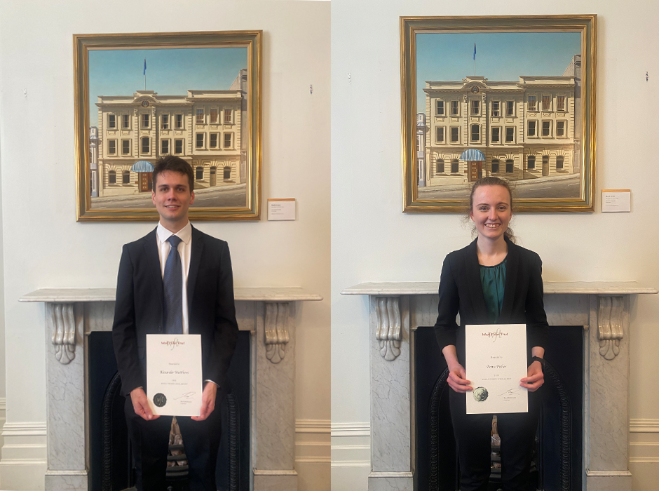 A man and a woman each holding a piece of paper