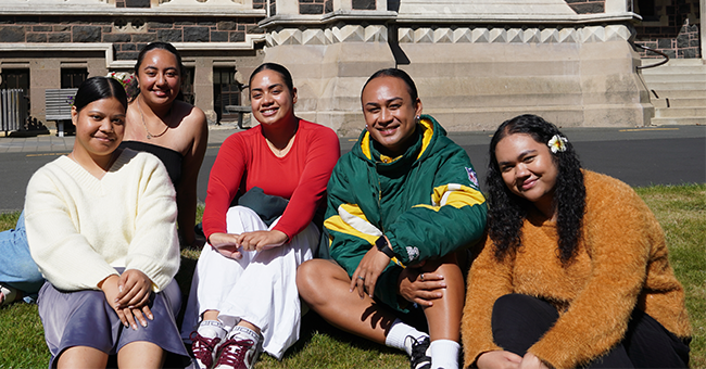 Five women sitting on the grass in the sun 