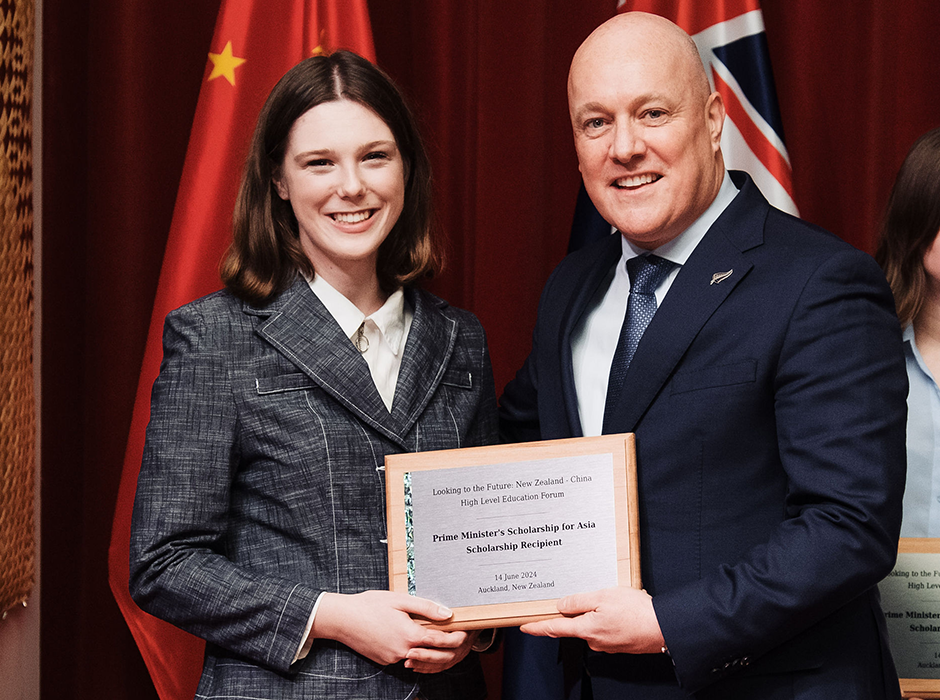 A woman stands next to a man while holding a plaque