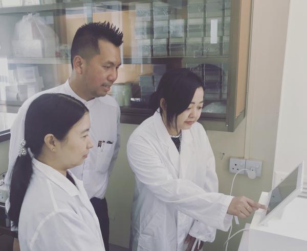 A photo of Dr Aung with two students working on the next-generation illumina iSeq sequencing at the National Tuberculosis Reference Laboratory, Myanmar