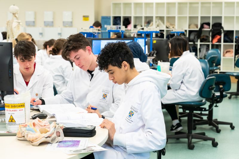 Students in lab coats in a lab