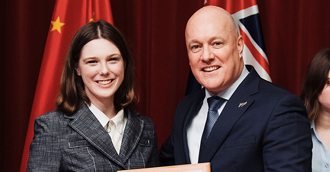 A woman standing next to a man while holding a plaque