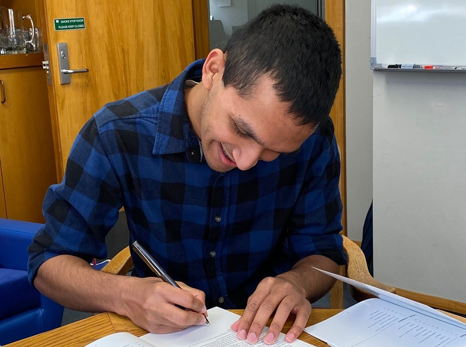 A man writing at a desk 