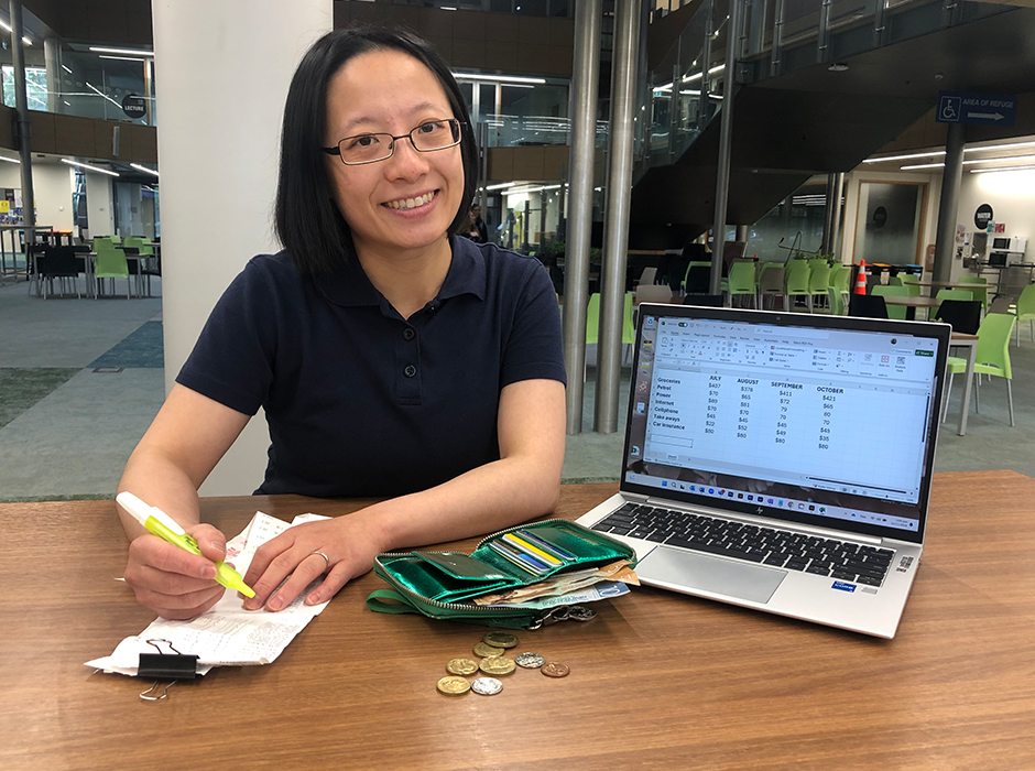 A woman sitting with a laptop. wallet and receipts 