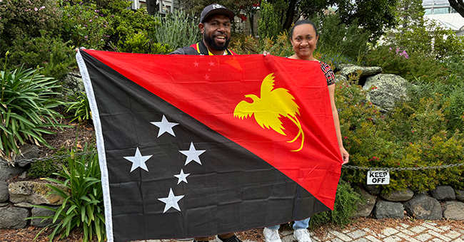 Bob Dadae, a member of the Papua New Guinea community, and Otago Melanesian Islands Students Association (OMISA) Cultural Rep Kirstie Kopi, right, present University College Warden Pauline Donovan with the Papua New Guinean flag.