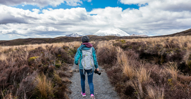 person walking in front of a mountain 