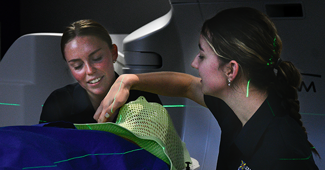 Ellen Emerson and a classmate work with a patient during a clinical placement.