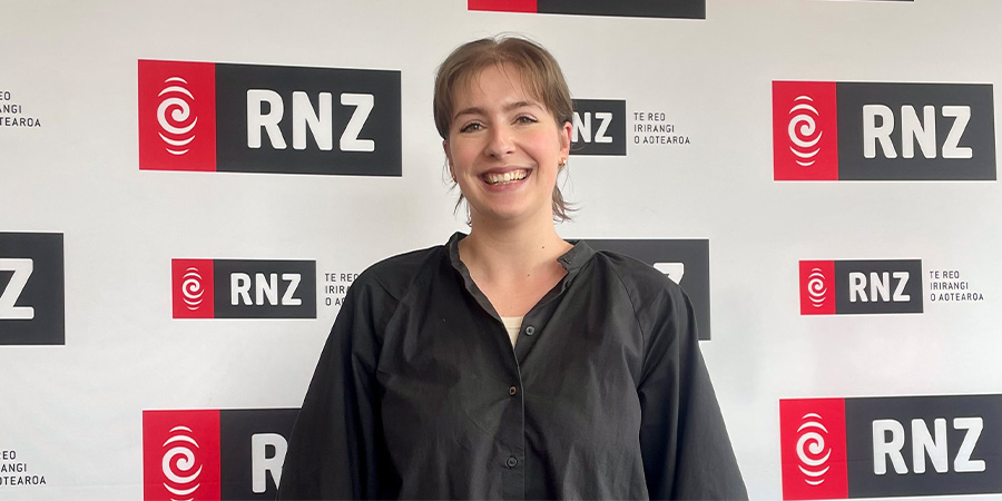 Bonnie Harrison infront of RNZ promotional screen 